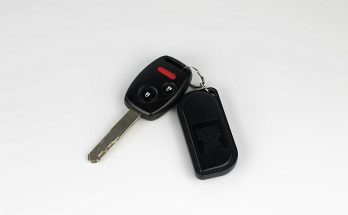 A close-up of a car key and remote on a white background.